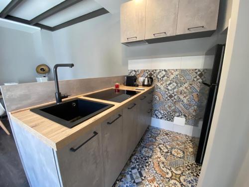 una cucina con lavandino e pavimento piastrellato di B&b Principe18 a Noci