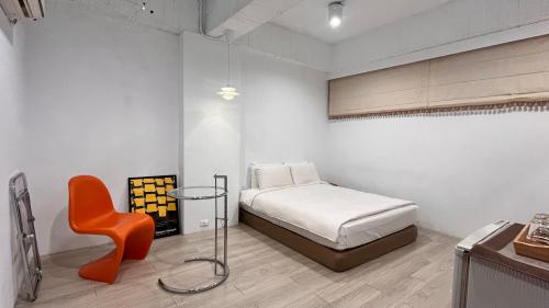 a bedroom with a bed and a orange chair at 日月潭魚池鄉秀水民宿Xiu Shui Hotel in Yuchi
