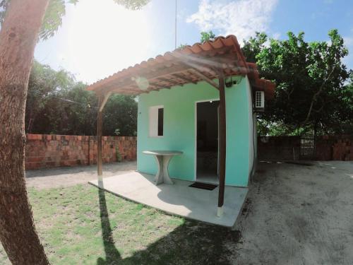 a small green house with a table in a yard at Mila chalé in Cruz