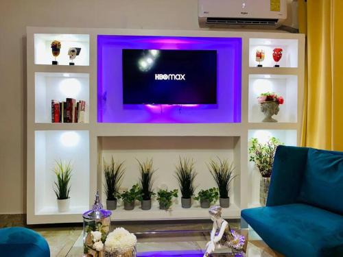 a living room with a tv on a shelf with plants at Romantic Studio w/Jacuzzi 15 min Airport in Ensanche Los Minas