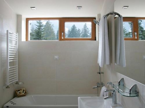 a bathroom with a bath tub and a sink at The Lodge Hotel in Borovets