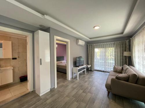 ein Wohnzimmer mit Sofa und ein Schlafzimmer in der Unterkunft X SUITE APART in Fethiye