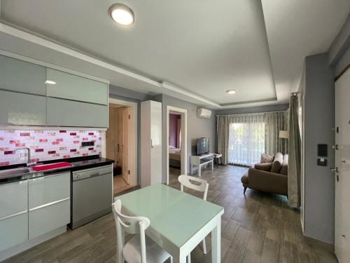 eine Küche und ein Wohnzimmer mit einem Tisch und Stühlen in der Unterkunft X SUITE APART in Fethiye