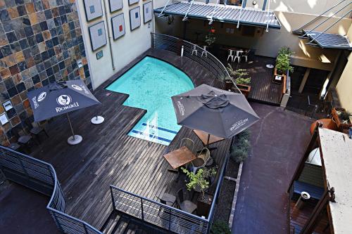 an overhead view of a swimming pool with two umbrellas at The Gold Hut in Johannesburg