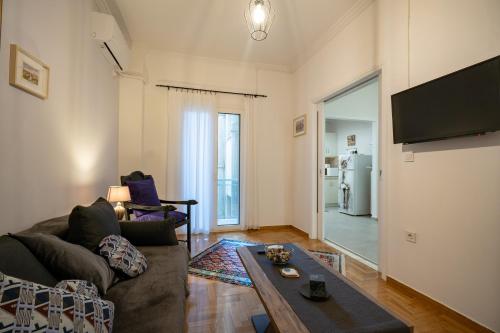 uma sala de estar com um sofá e uma mesa em Metaxourgeio metro st. 2 bedrms 4 pers. apartment. em Atenas