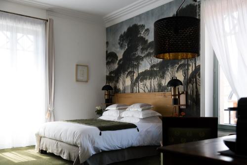 a bedroom with a bed and a painting on the wall at Le Passagran in Boën