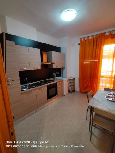 une cuisine avec des placards en bois et une table avec une table dans l'établissement Appartamento posizione comoda, à Collegno