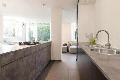 une cuisine avec deux lavabos et un grand comptoir dans l'établissement Het Wagenhuis, à Lo-Reninge