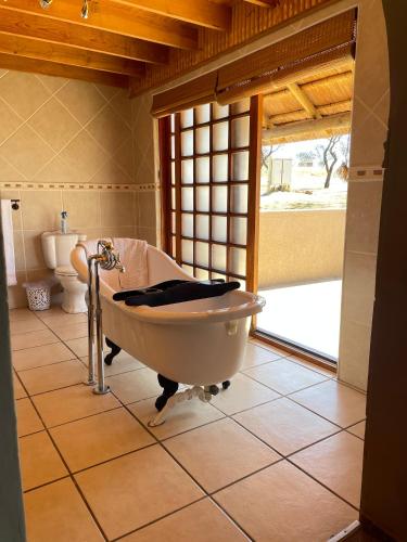 a bathroom with a bath tub and a toilet at Vaalkrans Game Lodge in Heilbron