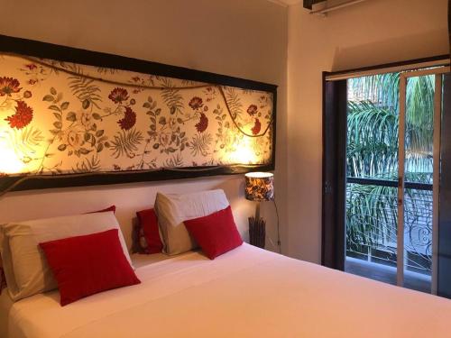 Un dormitorio con una cama con almohadas rojas y una ventana en Palma Hostel, en São Luís