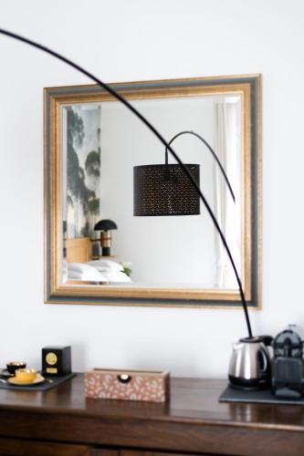 a black lamp sitting on a desk in front of a mirror at Le Passagran in Boën