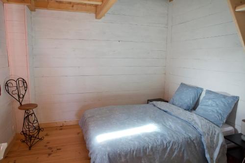 1 dormitorio con 1 cama en una habitación con suelo de madera en La Contesse en Masseube