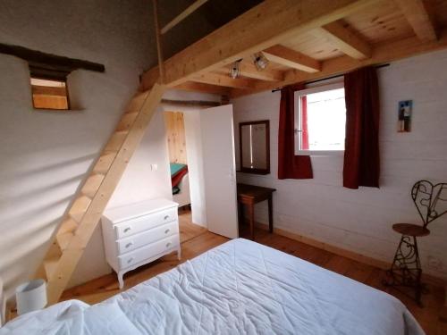 um quarto com uma cama branca e uma escada em La Contesse em Masseube
