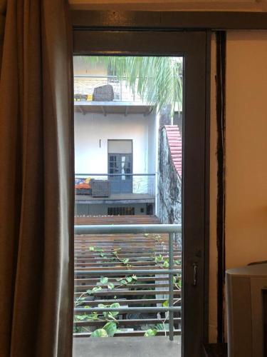 a door to a balcony with a view of a house at Palma Hostel in São Luís
