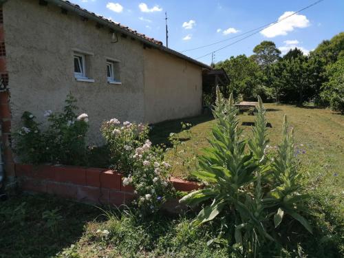 una casa con unas flores delante de ella en La Contesse en Masseube