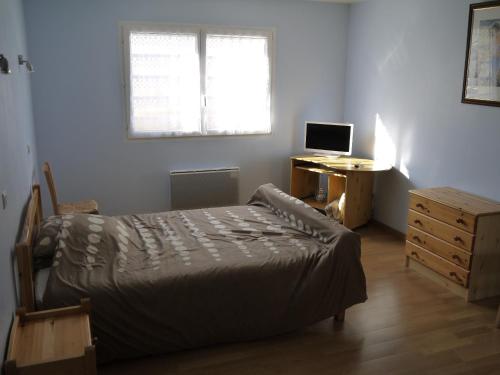 a bedroom with a bed and a desk with a computer at Chambres D'hotes Beaupel in Neuvy-en-Mauges