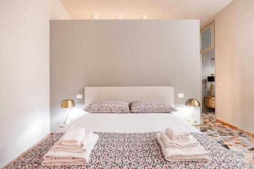 una camera da letto con un grande letto con asciugamani di BOOK NOW! Apt a 1 min walk from Duomo of Parma a Parma