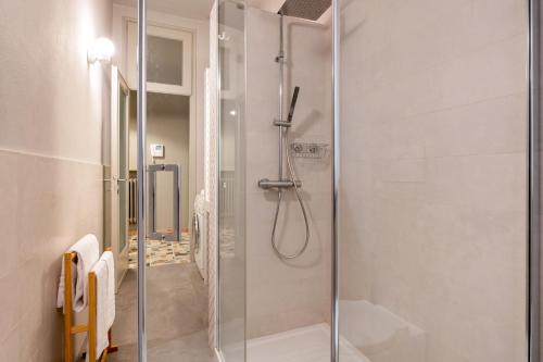 una doccia con porta in vetro in bagno di BOOK NOW! Apt a 1 min walk from Duomo of Parma a Parma