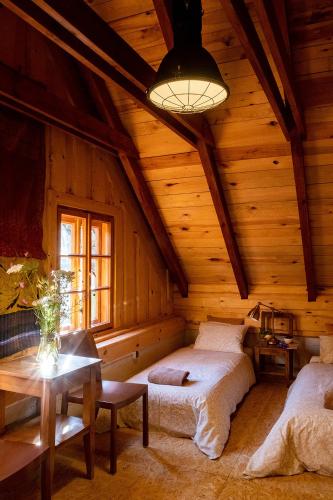 a bedroom with two beds in a wooden cabin at Domy w Lipowie - dom różowy in Lipowo
