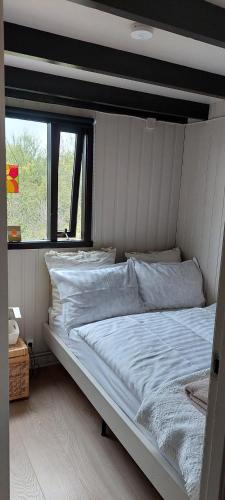 ein großes Bett in einem Zimmer mit Fenster in der Unterkunft Heimaland 1 in Selfoss