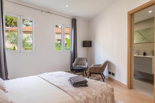 - une chambre avec un lit, une chaise et des fenêtres dans l'établissement SUPERBE PENTHOUSE PROCHE MONACO GRANDE TERRASSE, à Beausoleil
