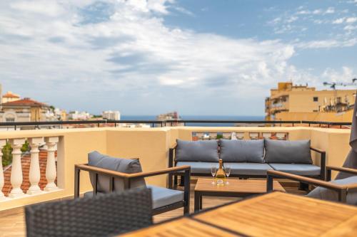 a balcony with chairs and tables and a view of the ocean at SUPERBE PENTHOUSE PROCHE MONACO GRANDE TERRASSE in Beausoleil