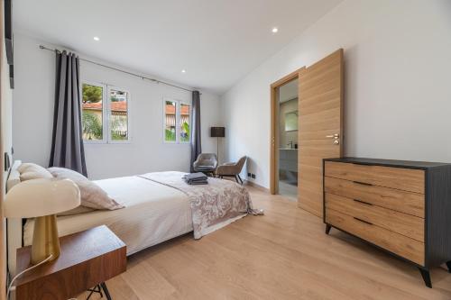 a bedroom with a bed and a dresser and a window at SUPERBE PENTHOUSE PROCHE MONACO GRANDE TERRASSE in Beausoleil