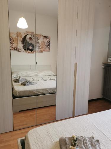 a bedroom with a mirrored closet and a bed at Una finestra sul verde in Sassello