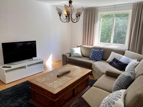 a living room with a couch and a tv at Fin lägenhet. Gångavstånd till Strömstads centrum. in Strömstad