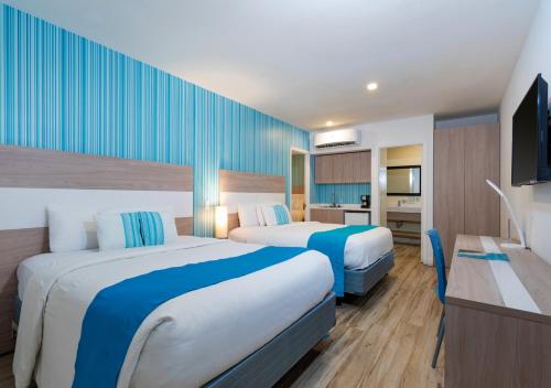 Habitación de hotel con 2 camas y TV en Aqualina Inn en San Andrés
