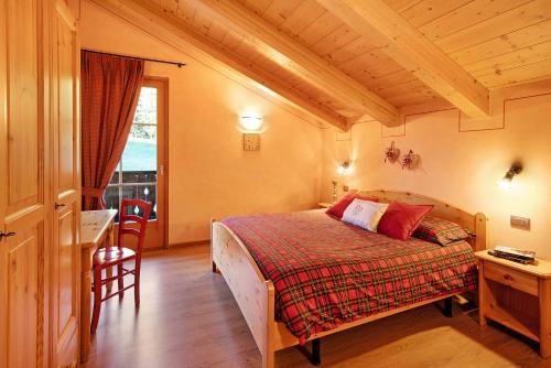 a bedroom with a bed and a table and a window at Stelle Chalet Martina in Livigno