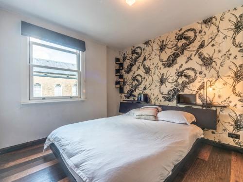 a bedroom with a large bed and a window at Pass the Keys Stylish Apartment In The Heart Of Richmond in Richmond