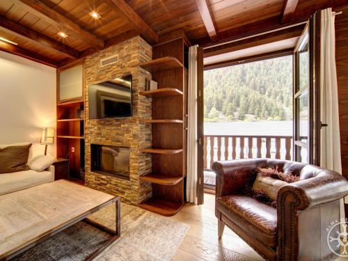 Una sala de estar con un sofá y una chimenea. en MONTGARRI de Alma de Nieve, en Naut Aran (Alto Arán)