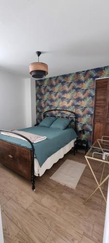 a bedroom with a bed with a wall at Appartement chaleureux en Ardèche in Châteaubourg