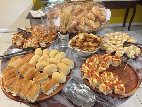 a table filled with different types of bread and pastries at Apart hotel Copacabana Próximo a praia in Rio de Janeiro