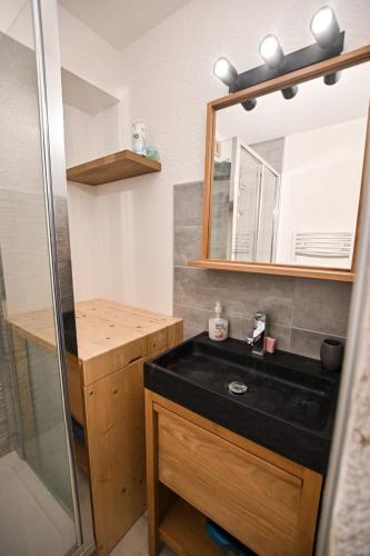 baño con lavabo negro y espejo en 24 M With Terrace Near The Center And The Slopes, en Saint-Gervais-les-Bains