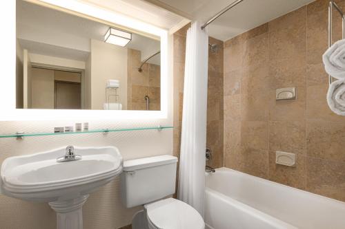 a bathroom with a sink and a toilet and a mirror at Holiday Inn Boston Bunker Hill Area, an IHG Hotel in Somerville