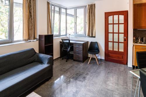 a living room with a couch and a desk at Darling Apartman in Szeged