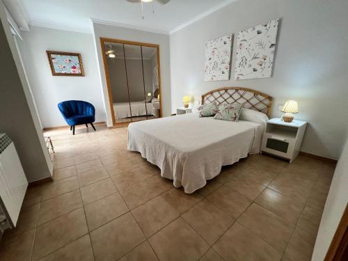 a bedroom with a bed and a blue chair at El Recreo, private Pool & Bbq in Godelleta
