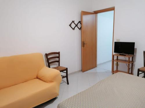 ein Wohnzimmer mit einem Sofa und einem TV in der Unterkunft Appartamento Bent el Rhia in Pantelleria