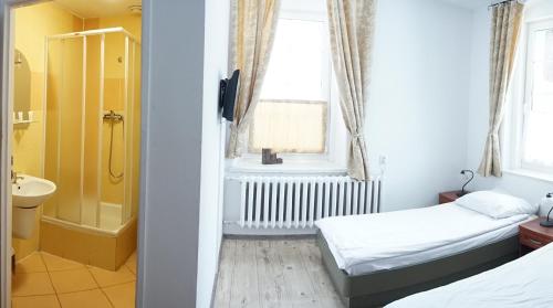 una camera con 2 letti e un bagno con doccia di Willa Dunajec a Kudowa-Zdrój