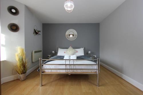 a bedroom with a bed and a chandelier at Charming 2 Bed 2 Bath Flat & Parking by CozyNest in Reading