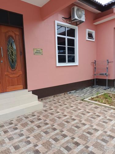 une maison avec un mur rose et une porte dans l'établissement Hana Homestay Kolam Terengganu, à Marang