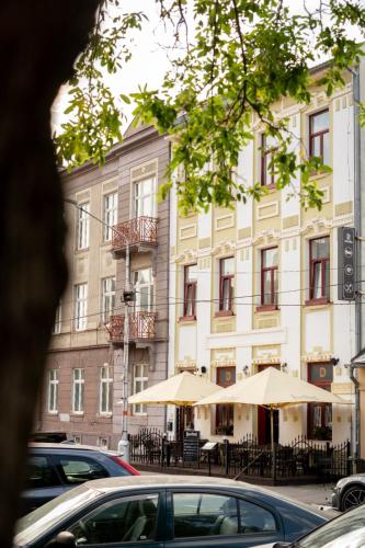 a building with tables and umbrellas in front of it at Penzión Deloris in Trenčín