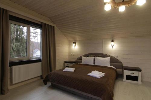 1 dormitorio con 1 cama con 2 toallas en Villa Medova, en Kosiv