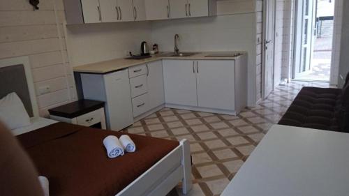 a small kitchen with white cabinets and a table at Villa Medova in Kosiv