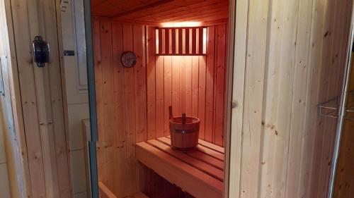 małą drewnianą saunę z wiadrem w obiekcie Feriendorf Südstrand Haus 23 w mieście Pelzerhaken