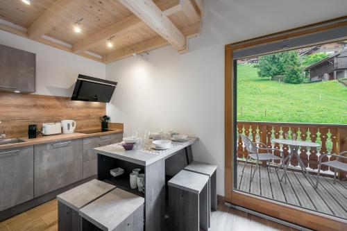 une cuisine avec une table et une grande fenêtre dans l'établissement Perle de savoie - Apt C706 - BO Immobilier - Châtel - Châtel Multipass Été 2025 en option au tarif de 3euros par jour et par personne, à Châtel