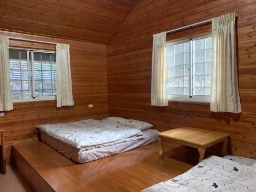Duas camas num quarto com paredes e janelas de madeira em UT Chaung Homestay 