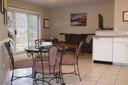 Il comprend une cuisine et un salon avec une table et des chaises. dans l'établissement Paradise Canyon Golf Resort - Luxury Condo M405, à Lethbridge
